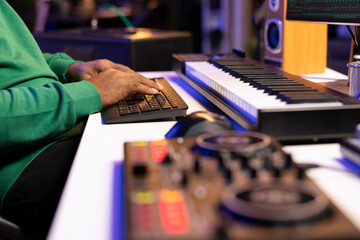 Leinwandbilder - Sound engineer working with mixing console and daw software to edit audio recordings, adjusting volume levels with pre amp knobs in his home studio. Producer uses stereo gear. Close up.