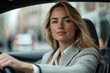 © A.Ex - Woman driving a car in city traffic, focusing on the road ahead. Sunny day with busy street visible through the windshield.