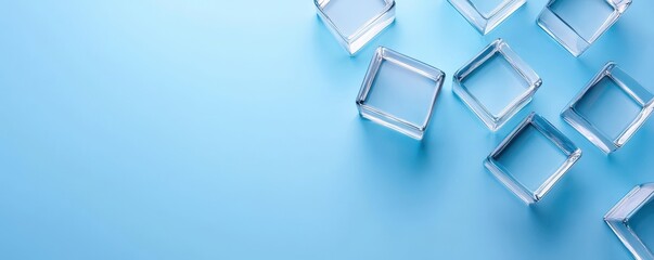 Aufkleber - A minimalist arrangement of clear glass cubes on a soft blue background, creating a clean and modern aesthetic.