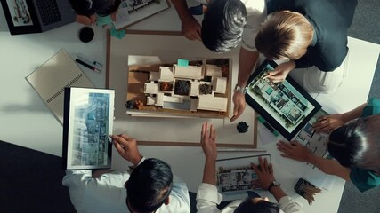 Poster - top down view of manager pointing at house model and explain building design. aerial view of archite