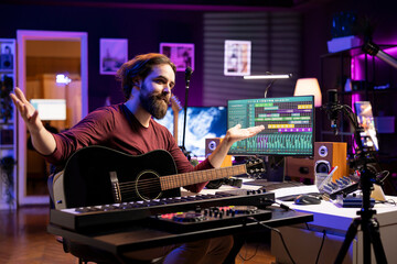 Poster - Songwriter recording himself in home studio singing and playing guitar, filming video about learning to sing popular songs. Producer composer teaching online master class lessons on phone.