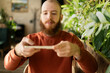 © Andrii Lysenko - Bearded redhead man scanning remote check deposit while using mobile phone