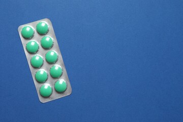 Wall Mural - Pills in blister pack on blue background, close up