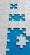 © PhotoMaster - Close-up of incomplete white puzzle pieces on a blue surface, showcasing problem-solving, teamwork and the challenge of filling missing connections