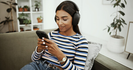 Aufkleber - Headphones, online and woman with phone on sofa for social media, streaming subscription and radio. Happy, home and girl on smartphone listening to audio, playlist and podcast to relax in living room
