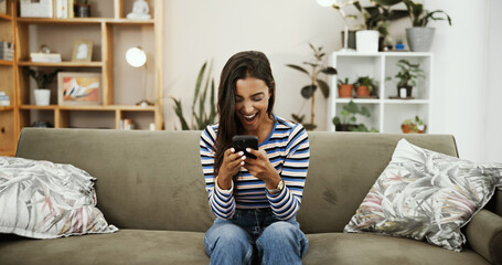 Aufkleber - Phone, excited and Indian woman on sofa for online chatting, social media and internet on weekend. Relax, home and person on smartphone for winning, website and payment notification in living room
