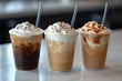© Niphaphan - Set of three iced coffee drinks in clear cups, each with different milk ratios, straws, and ice cubes