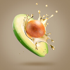 Wall Mural - avocado with oil splash on a light brown background