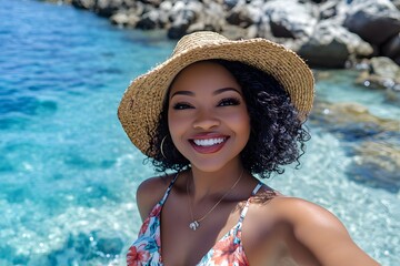 Wall Mural - a beautiful black woman taking a selfie at the beach, wearing a floral dress and straw hat and smili