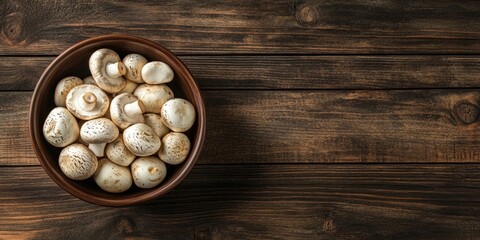 Poster - Fresh white champignon mushrooms in a brown bowl positioned centrally on a rustic wooden surface with ample copy space to the right