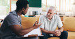 © peopleimages.com - Doctor talking, old man and writing in home visit, assessment and medical file for health checklist. Speaking, insurance and nurse helping elderly patient file for checkup, advice and illness support