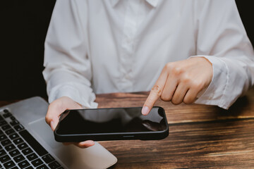 Poster - Person Using Smartphone While Working on Laptop at Wooden Desk