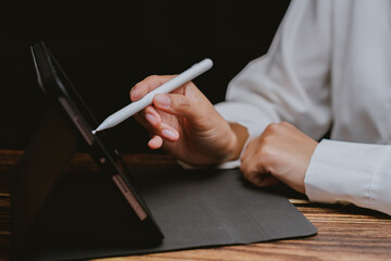 Poster - Hand Holding Stylus on Tablet in Professional Workspace Setting