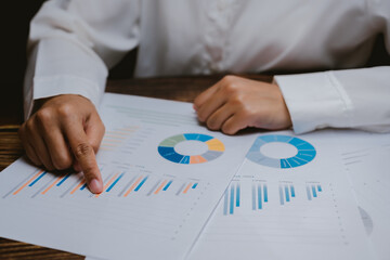 Poster - Person Analyzing Business Reports with Graphs and Charts on Table
