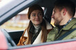 © DragonImages - Smiling couple dressed warmly sitting inside car with a scenic background and enjoying cozy winter day, man and woman wearing winter clothing and engaging in a light conversation