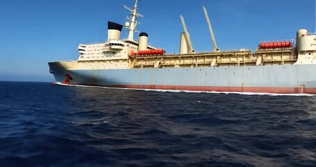 Aufkleber - Large Gray Ship Sailing on Blue Ocean Water Under a Clear Blue Sky