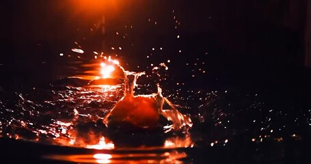 Aufkleber - Orange Falling on the Water Splash with Red Lighting, Dark Background and Orange Light.  High-Speed Photography Concept