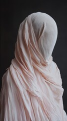Poster - A mysterious figure, completely covered in flowing pale pink fabric, stands in quiet contemplation. The dark backdrop enhances the ethereal quality, inviting curiosity and calm reflection