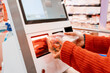 © EdNurg - Customer scanning groceries at self checkout kiosk in supermarket