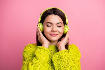 Wall Mural - Stylish Female Relaxing With Yellow Headphones Against a Pink Backdrop