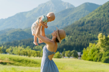 Wall Mural - Mother and her child playing in nature. Happy healthy family. Positive emotions.