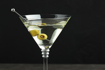 Wall Mural - Martini cocktail with olives in glass on black background, closeup