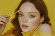 © vstudio - Portrait of woman with red hair applying clear liquid product to forehead against yellow backdrop