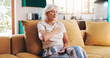 © KayExam/peopleimages.com - Home, heart attack and senior woman on sofa, chest pain and cardiac arrest in living room. Pensioner, apartment and person on couch, asthma and emergency in lounge, pressure, stress or cardiovascular
