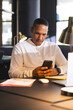 © Wavebreak Media - Businessman using smartphone at office desk, focusing on work at night