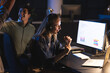 © Wavebreak Media - Businesswoman wearing headset analyzing data on computer at night office