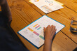 © Wavebreak Media - Reviewing colorful business charts and graphs on wooden desk at night, at office