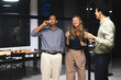 © Wavebreak Media - Diverse colleagues enjoying drinks and laughing together during office celebration at night