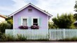 © Lazar - A picturesque lavender cottage adorned with blooming flowers and a white picket fence, radiating tranquility and classic charm in a lush green setting.