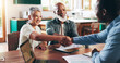 © peopleimages.com - Handshake, meeting and consulting with old couple with financial advisor for retirement fund, fraud protection and pension planning. Documents, greeting and shaking hands with people at home