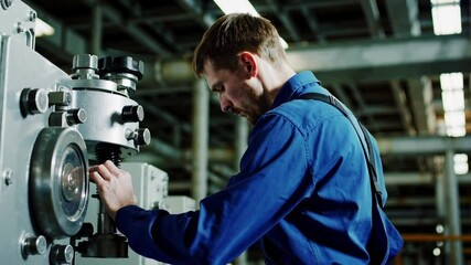 Aufkleber - Professional engineer wearing protective uniform carefully adjusting complex industrial machinery during precision maintenance work within manufacturing facility's metalworking environment