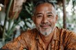 © typepng - The casual lifestyle of a retired Hispanic person or an Asian adult man is captured in a portrait of a happy mature man with a stylish short white and grey beard looking at the camera outdoors