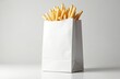 © Vadym - Golden french fries in white paper bag on white table. Takeaway fast food snack. Fried potatoes in a paper container, simple studio shot, minimalist design, greasy junk food.