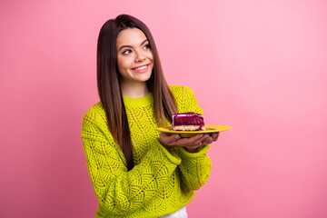 Wall Mural - Cheerful Young Woman Holding a Slice of Cake on a Plate Against a Vibrant Pink Background