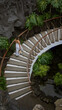 © Krakenimages.com - Woman walking down elegant curved staircase in museo del campesino with lush greenery and volcanic rock backdrop in lanzarote, canary islands