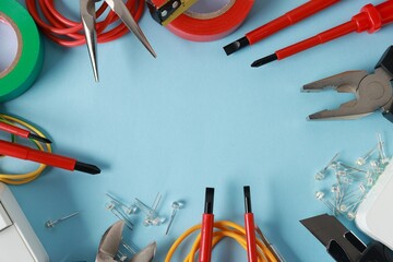 Poster - Frame of different electrical tools on light blue background, flat lay. Space for text