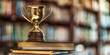 © Duka Mer - The golden trophy sits atop books with a blurred background, winning an educational concept stock photo contest.