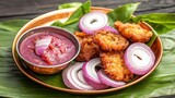 Copper dishes with national Indian food Concept, Copper Plate with Onion Pakoras and Tama Sauce on Green Leaves for Delicious Indian Snack Platter