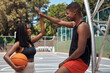 © peopleimages.com - High five, basketball and black couple on court for exercise, workout and training for match. Fitness, sports and man with woman, ball outdoors and playing game for practice and competition goals