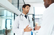 © peopleimages.com - Men, doctor and discussion with colleague at hospital for proposal, medical campaign or idea. Male people, surgeons or healthcare employees talking with health advice for procedure or clinic strategy