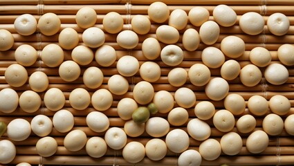 Aufkleber - variety of small round white and beige beads arranged on a woven bamboo mat surface