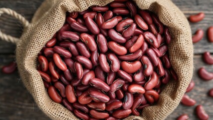 Poster - Red kidney beans in a burlap sack on a wooden surface with some beans scattered around