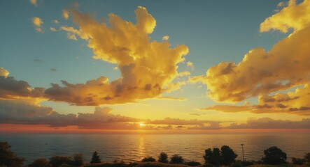 Poster - Vibrant summer sunset over the ocean with a stunning gradient of yellow and orange clouds against a serene blue sky and calm water horizon.