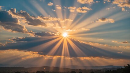 Aufkleber - Sunrise with dramatic sunrays breaking through clouds over mountainous landscape under blue sky