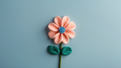 Poster - pink flower made of soft clay with blue center and green leaves on a light blue background