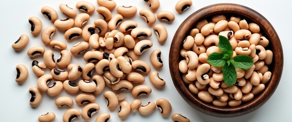 Poster - Black eyed peas and white beans in wooden bowl surrounded by scattered beans on white background Healthy eating vegetable protein concept